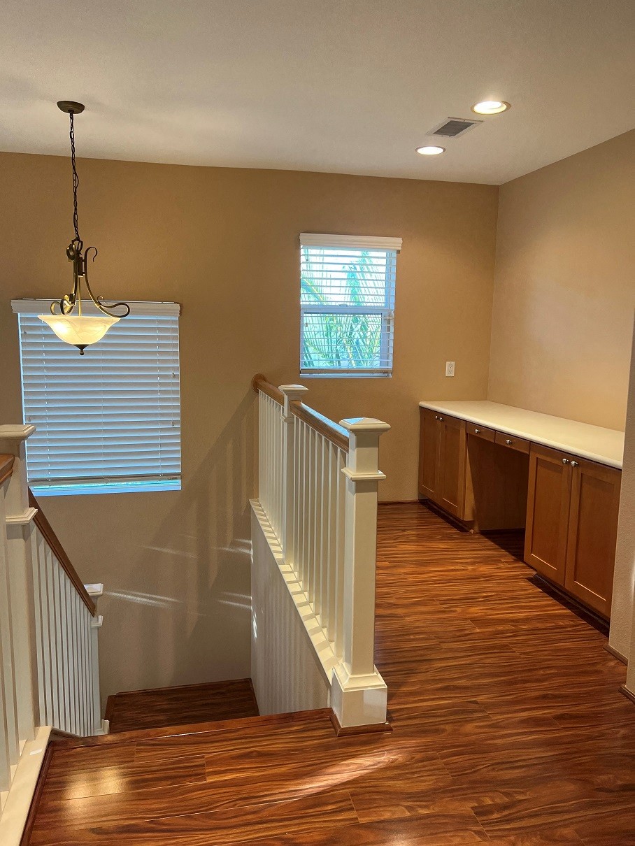 a stairway in a home with wood floors and a window